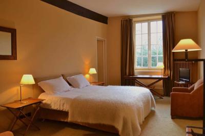 Chambre lumineuse avec un grand lit, des lampes de chevet, un bureau, une télévision et une grande fenêtre donnant sur l…