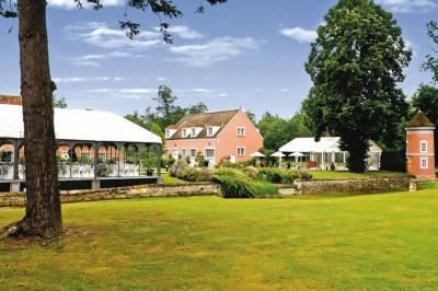 Chambre lumineuse avec un grand lit, des lampes de chevet, un bureau, une télévision et une grande fenêtre donnant sur l…