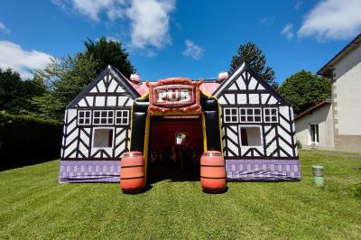 Structure gonflable jungle avec animaux et toboggan, entourée de feuilles, avec détails de location et caractéristiques.