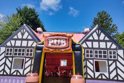 Structure gonflable jungle avec animaux et toboggan, entourée de feuilles, avec détails de location et caractéristiques.