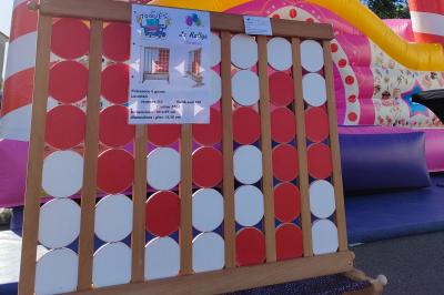 Structure gonflable jungle avec animaux et toboggan, entourée de feuilles, avec détails de location et caractéristiques.