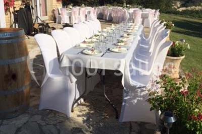 Matériel de sonorisation et d'éclairage installé sur deux tables recouvertes de nappes blanches dans une pièce lumineuse.