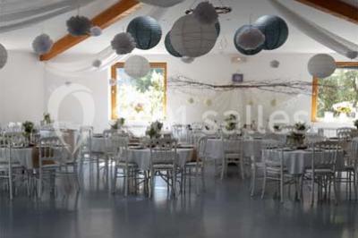 Matériel de sonorisation et d'éclairage installé sur deux tables recouvertes de nappes blanches dans une pièce lumineuse.