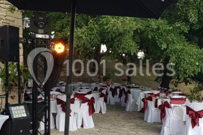 Matériel de sonorisation et d'éclairage installé sur deux tables recouvertes de nappes blanches dans une pièce lumineuse.