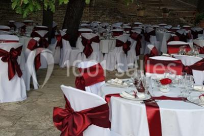 Matériel de sonorisation et d'éclairage installé sur deux tables recouvertes de nappes blanches dans une pièce lumineuse.