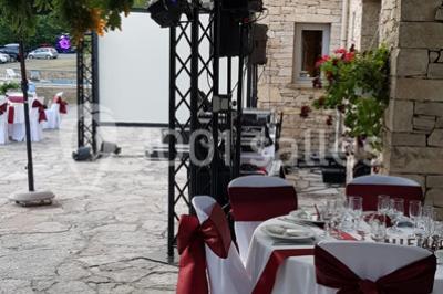 Matériel de sonorisation et d'éclairage installé sur deux tables recouvertes de nappes blanches dans une pièce lumineuse.