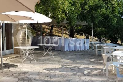 Matériel de sonorisation et d'éclairage installé sur deux tables recouvertes de nappes blanches dans une pièce lumineuse.