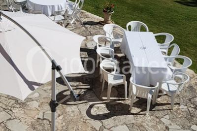 Matériel de sonorisation et d'éclairage installé sur deux tables recouvertes de nappes blanches dans une pièce lumineuse.