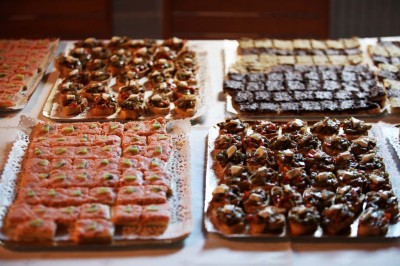 Matériel de sonorisation et d'éclairage installé sur deux tables recouvertes de nappes blanches dans une pièce lumineuse.