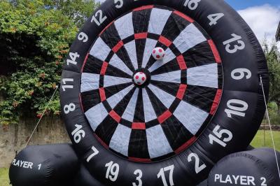 Miniature Le Rallye Loc #3 Un jeu de puissance 4 géant en bois placé sur une pelouse, à côté d'une girouette rouge sous des arbres.