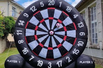 Miniature Le Rallye Loc #4 Un jeu de puissance 4 géant en bois placé sur une pelouse, à côté d'une girouette rouge sous des arbres.