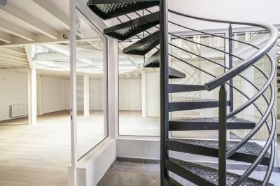 Espace intérieur lumineux avec parquet clair, verrière au plafond et ouverture vitrée au sol.