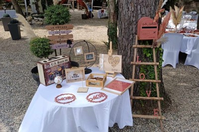 Salon lumineux avec mobilier en résine tressée, plantes vertes, tapis rond en jute et rideaux sombres.