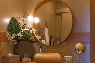 Vue d'une piscine entourée de végétation, avec un jacuzzi, des parasols et un paysage de campagne en arrière-plan.