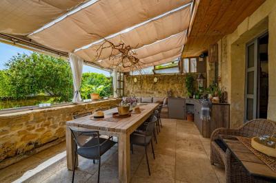 Vue d'une piscine entourée de végétation, avec un jacuzzi, des parasols et un paysage de campagne en arrière-plan.