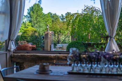 Vue d'une piscine entourée de végétation, avec un jacuzzi, des parasols et un paysage de campagne en arrière-plan.