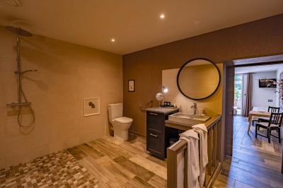 Vue d'une piscine entourée de végétation, avec un jacuzzi, des parasols et un paysage de campagne en arrière-plan.