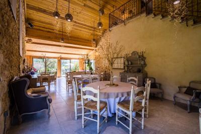 Vue d'une piscine entourée de végétation, avec un jacuzzi, des parasols et un paysage de campagne en arrière-plan.