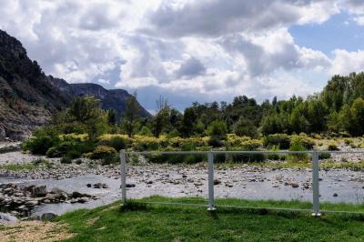 Salle de réception en extérieur décorée pour un événement, avec tables dressées, fleurs et voilages suspendus.