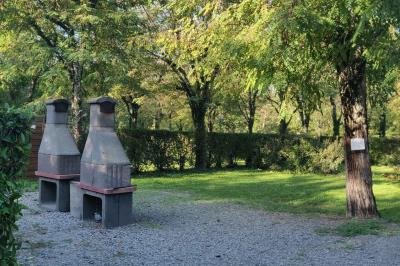 Salle de réception en extérieur décorée pour un événement, avec tables dressées, fleurs et voilages suspendus.