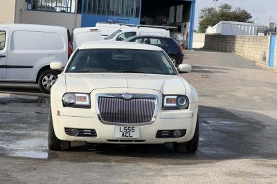 Limousine blanche sur une plateforme éclairée par des néons roses, avec texte ’Offre exclusive’ et prix affiché.