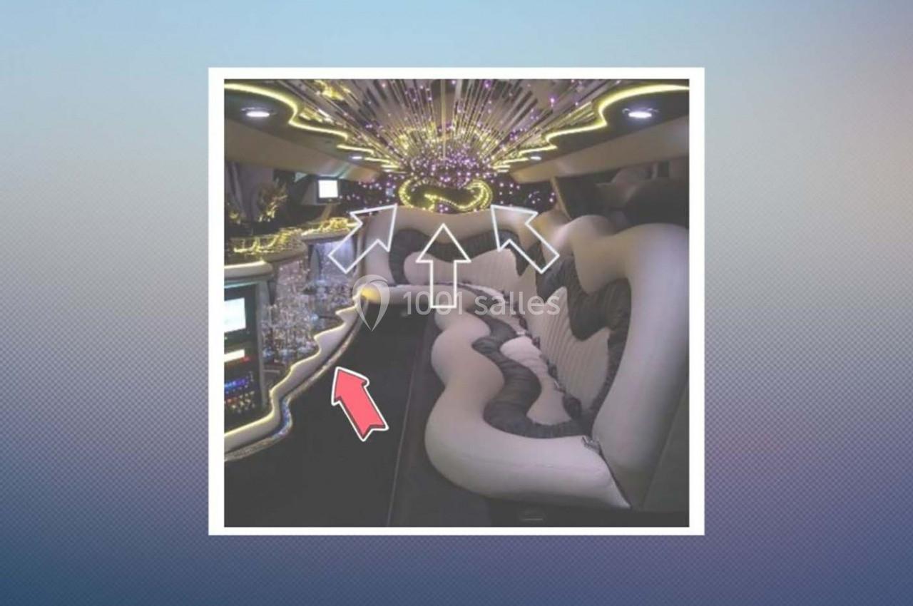 Intérieur d'une limousine avec banquettes en cuir, éclairage LED coloré et bar intégré.