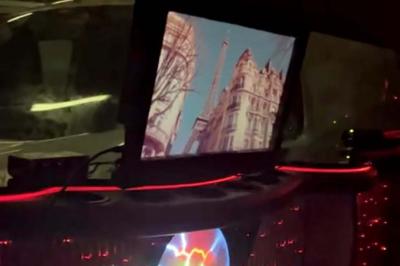 Limousine blanche sur une plateforme éclairée par des néons roses avec le texte ’Offre exclusive’ et un prix affiché.