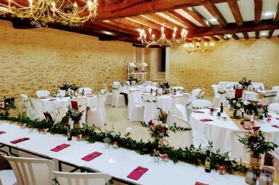 Train en bois pour enfants sur une pelouse, avec une tour en pierre et des arbres en arrière-plan au coucher du soleil.