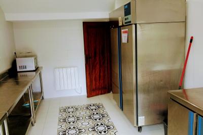 Train en bois pour enfants sur une pelouse, avec une tour en pierre et des arbres en arrière-plan au coucher du soleil.