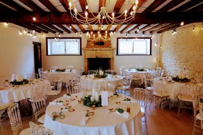 Train en bois pour enfants sur une pelouse, avec une tour en pierre et des arbres en arrière-plan au coucher du soleil.