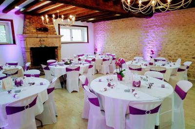 Train en bois pour enfants sur une pelouse, avec une tour en pierre et des arbres en arrière-plan au coucher du soleil.