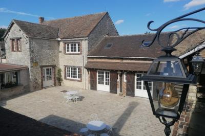 Train en bois pour enfants sur une pelouse, avec une tour en pierre et des arbres en arrière-plan au coucher du soleil.