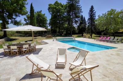 Train en bois pour enfants sur une pelouse, avec une tour en pierre et des arbres en arrière-plan au coucher du soleil.
