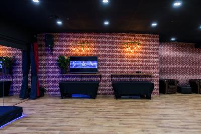 Salle lumineuse avec parquet, murs blancs, plantes décoratives et grandes fenêtres laissant entrer la lumière naturelle.