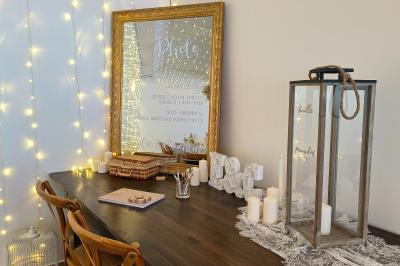 Centre de table floral avec roses blanches, feuillage et bougies blanches, sur une table de réception décorée en bleu et…