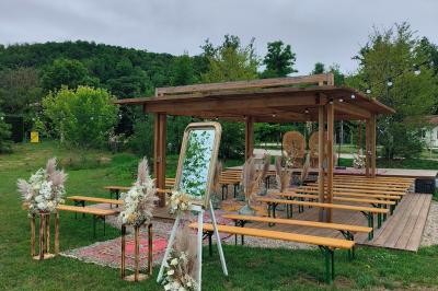 Centre de table floral avec roses blanches, feuillage et bougies blanches, sur une table de réception décorée en bleu et…