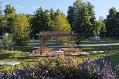 Centre de table floral avec roses blanches, feuillage et bougies blanches, sur une table de réception décorée en bleu et…