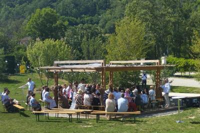 Centre de table floral avec roses blanches, feuillage et bougies blanches, sur une table de réception décorée en bleu et…