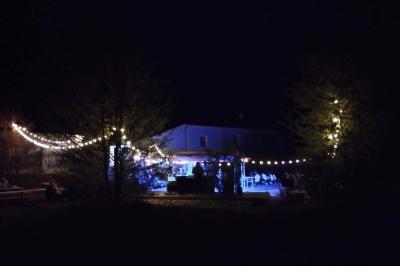 Centre de table floral avec roses blanches, feuillage et bougies blanches, sur une table de réception décorée en bleu et…