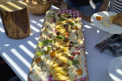 Centre de table floral avec roses blanches, feuillage et bougies blanches, sur une table de réception décorée en bleu et…