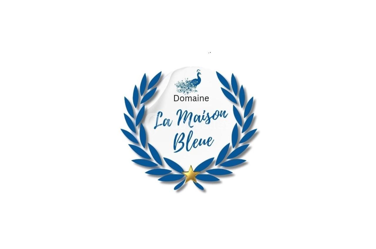 Logo du Domaine La Maison Bleue avec un paon stylisé, une couronne de laurier bleue et une étoile dorée.