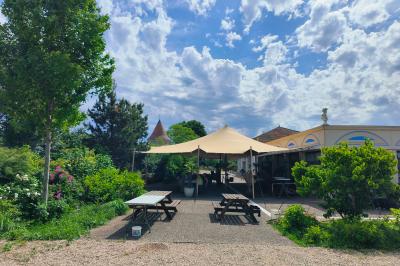 Centre de table floral avec roses blanches, feuillage et bougies blanches, sur une table de réception décorée en bleu et…