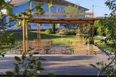 Centre de table floral avec roses blanches, feuillage et bougies blanches, sur une table de réception décorée en bleu et…