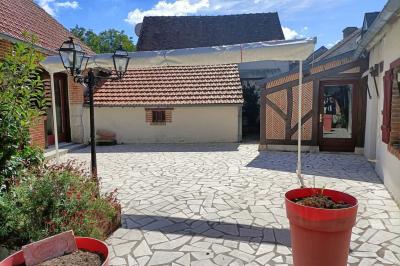 Un groupe de personnes assises et debout dans une salle avec des poutres apparentes, participant à une présentation.
