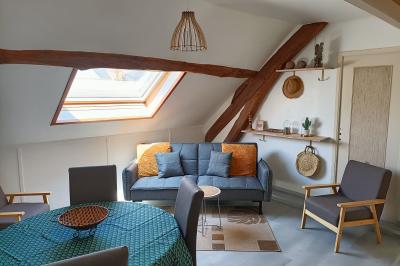Un groupe de personnes assises et debout dans une salle avec des poutres apparentes, participant à une présentation.