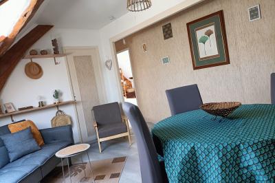 Un groupe de personnes assises et debout dans une salle avec des poutres apparentes, participant à une présentation.