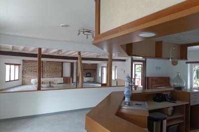 Un groupe de personnes assises et debout dans une salle avec des poutres apparentes, participant à une présentation.