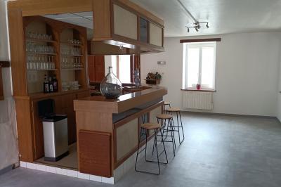 Un groupe de personnes assises et debout dans une salle avec des poutres apparentes, participant à une présentation.