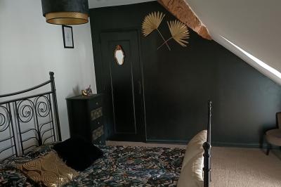 Un groupe de personnes assises et debout dans une salle avec des poutres apparentes, participant à une présentation.