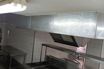 Un groupe de personnes assises et debout dans une salle avec des poutres apparentes, participant à une présentation.